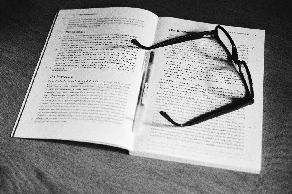 A text book, pen and glasses.